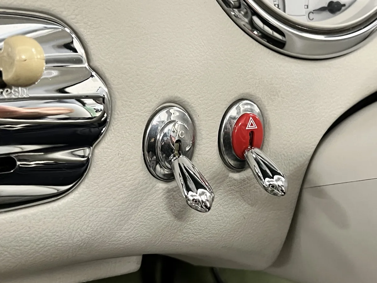 Chrome toggle switches and hazard button in a Nissan Figaro