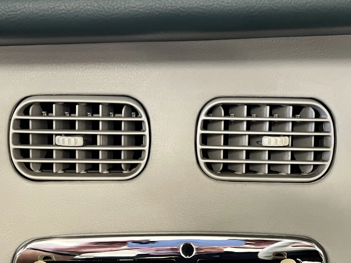 Chrome-edged dashboard air vents in a Nissan Figaro