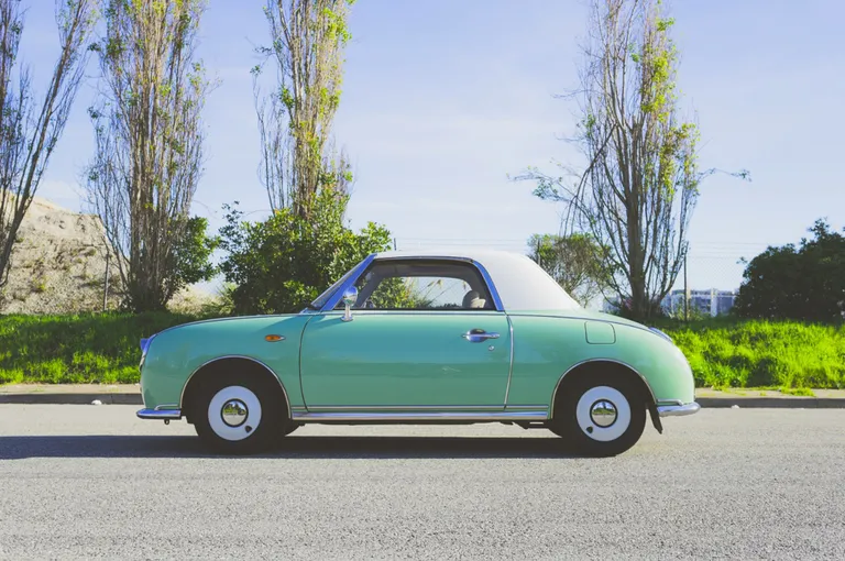 Nissan Figaro in side profile with the roof up