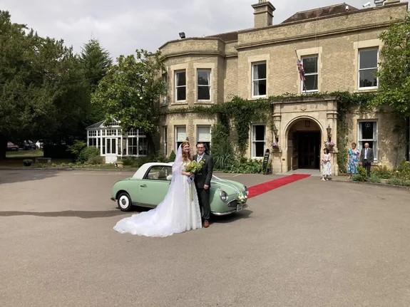 Nissan Figaro wedding car and bride outside Woodland Manor Hotel at Clapham, Bedford