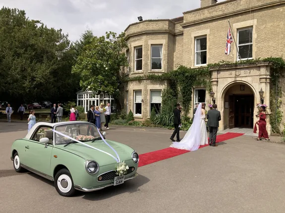 Classic Nissan Figaro wedding car on the red carpet at a Bedford wedding reception