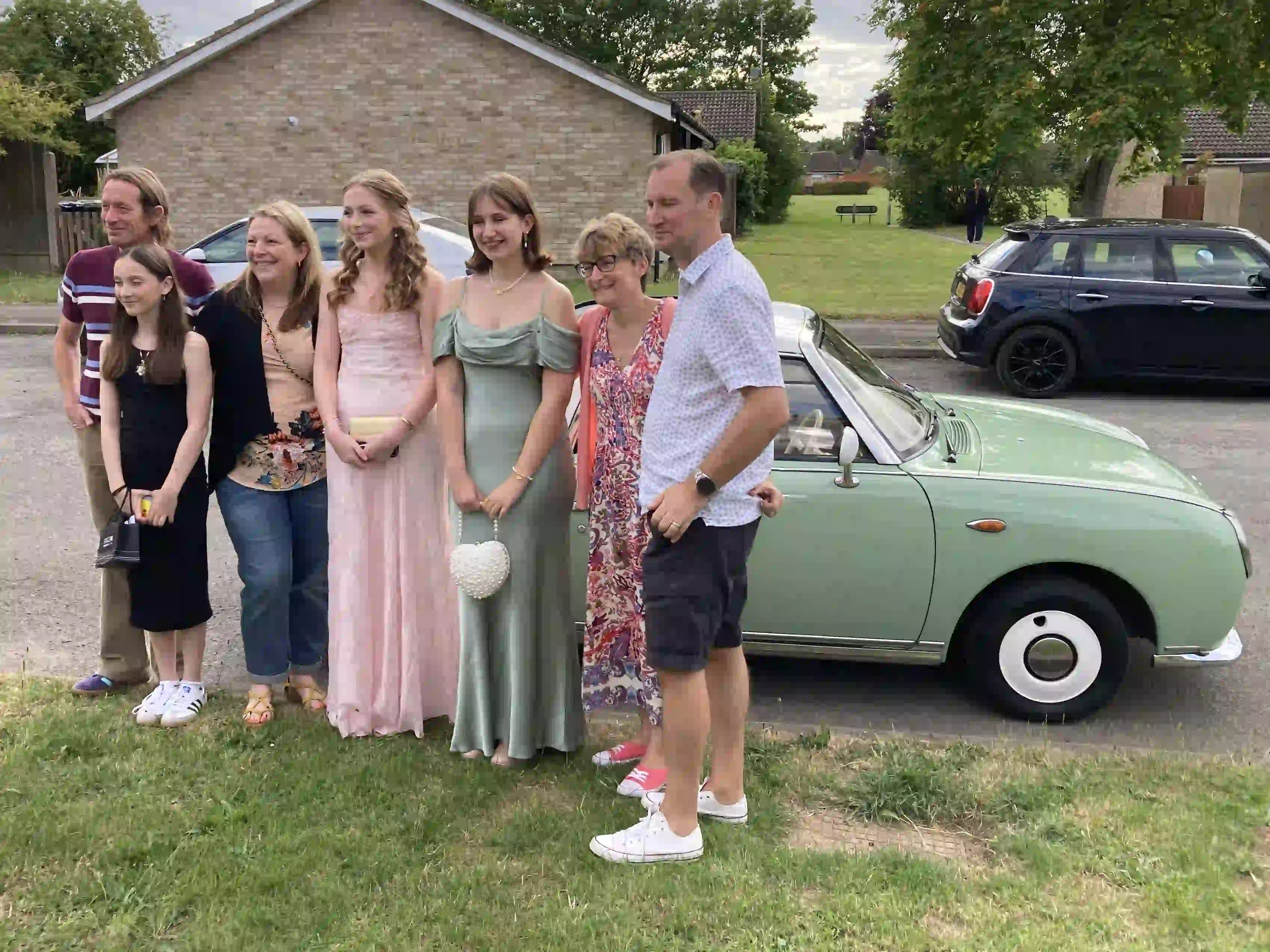 Jessica and Imogen with their family beside a Nissan Figaro prom car before their Sawston prom