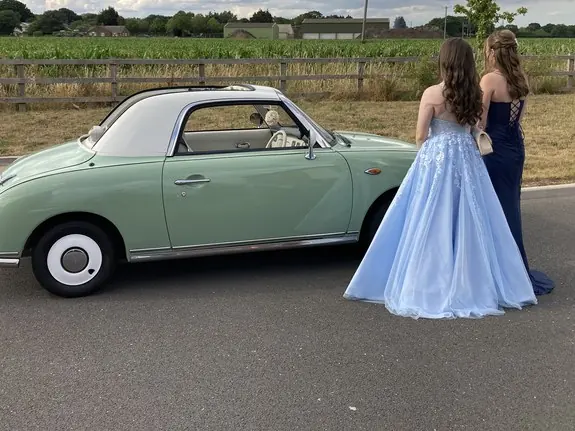 Nissan Figaro prom car with two girls in prom dresses