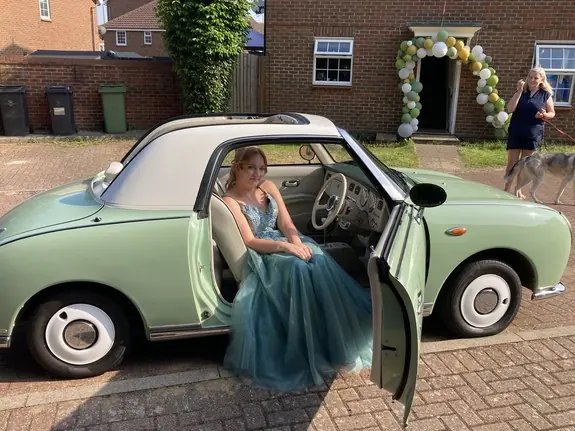Nissan Figaro prom car with the door open on a driveway